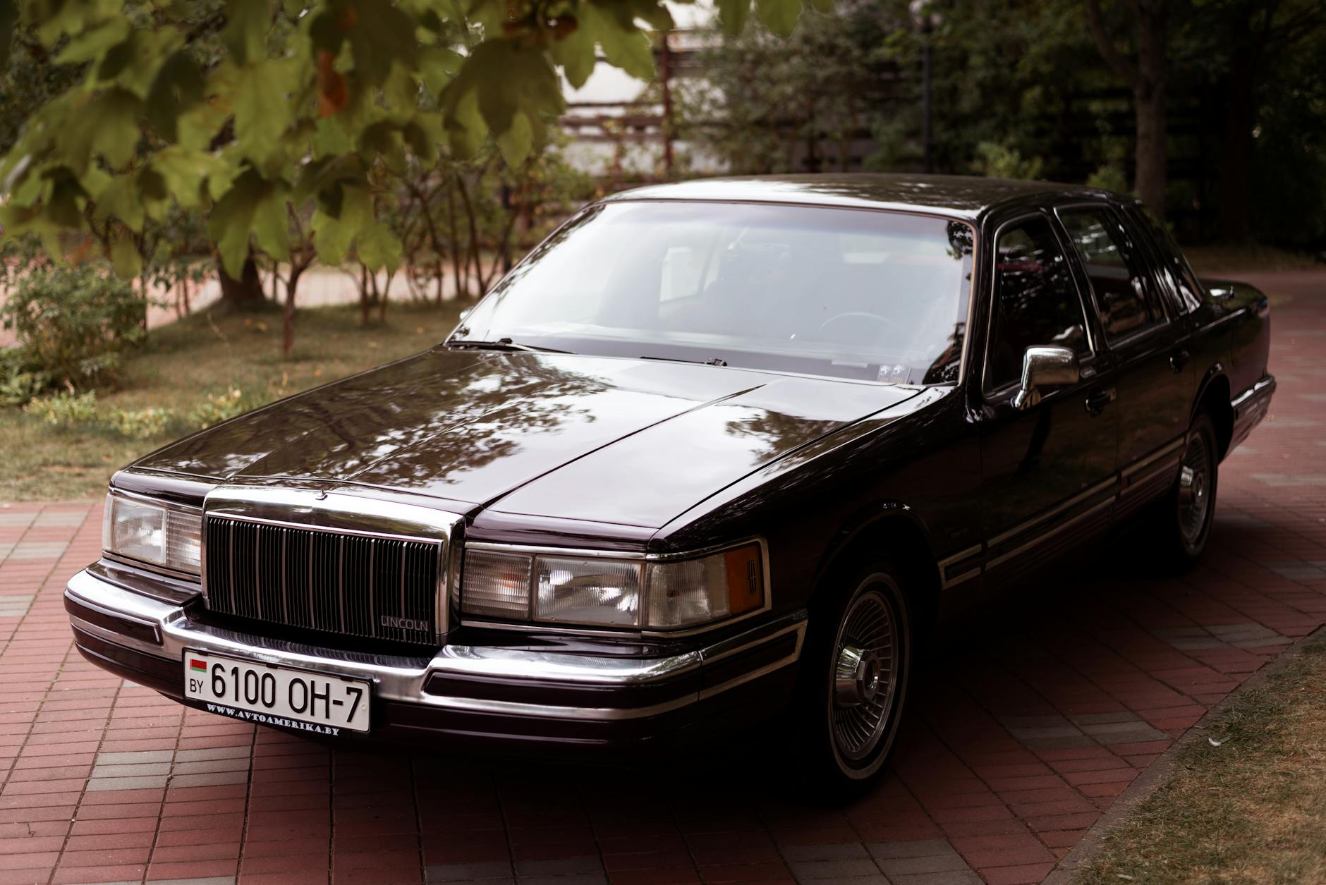Klasyczny Lincoln Town Car z 1992 roku na podjeździe wśród drzew