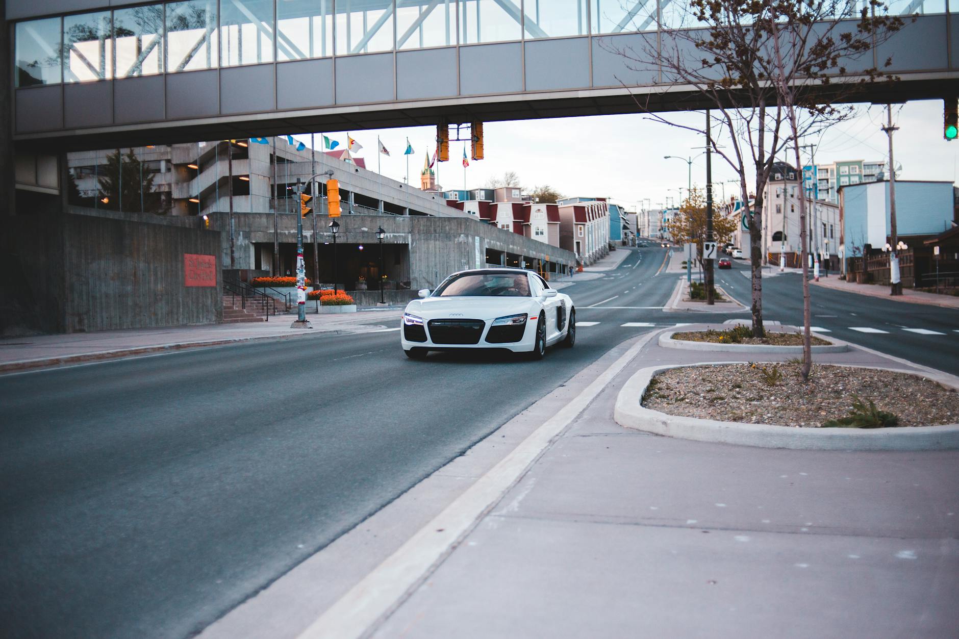 Biały Rolls-Royce jedzie pustą ulicą po letnim, miejskim asfalcie