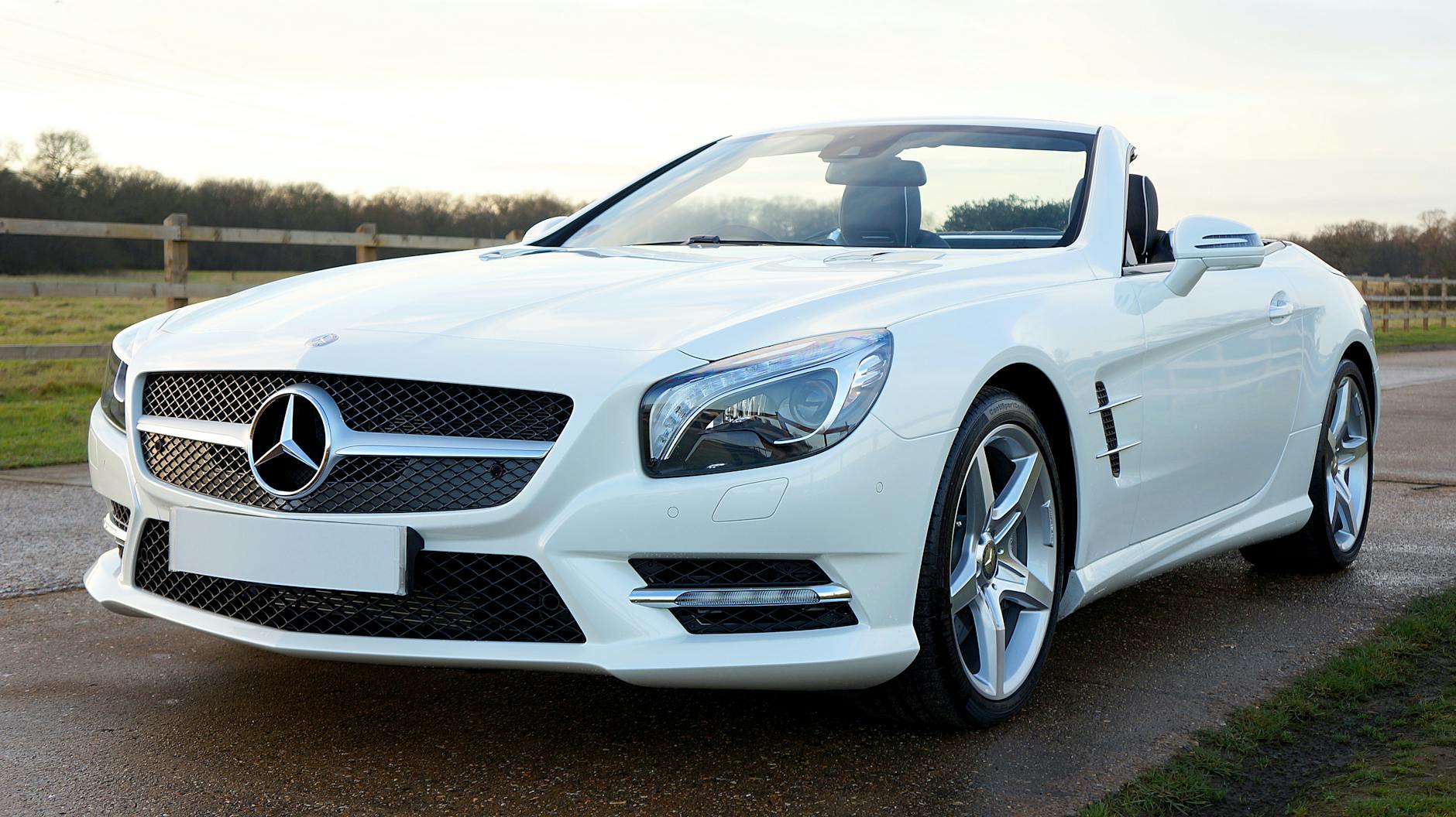 Wynajem Ferrari na miesiąc czy rok – porównanie opcji, cen i dokumentów Białe cabriolet Mercedes na wiejskiej drodze w Wielkiej Brytanii