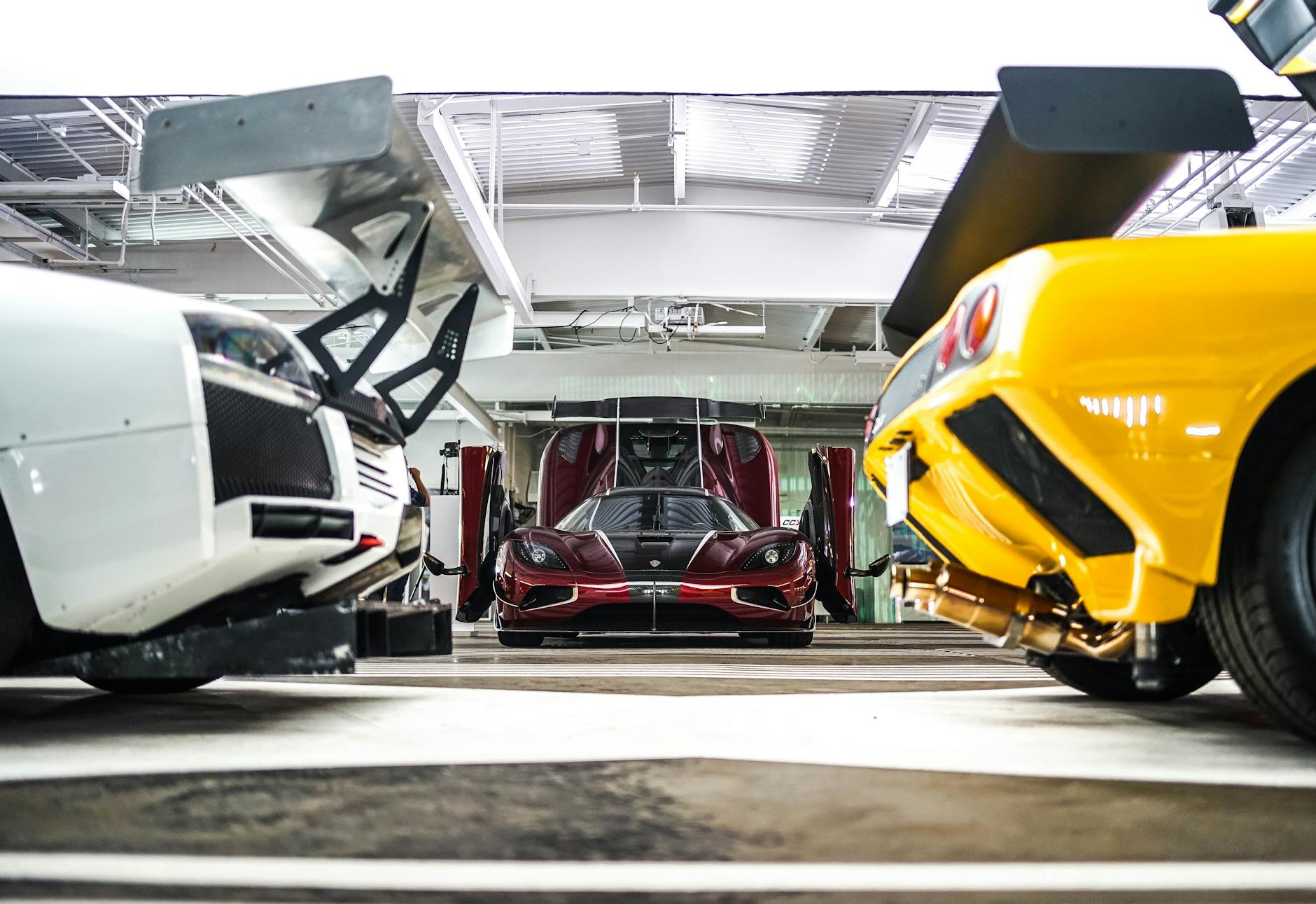 Ferrari i inne kolorowe superauta w nowoczesnym, oświetlonym garażu