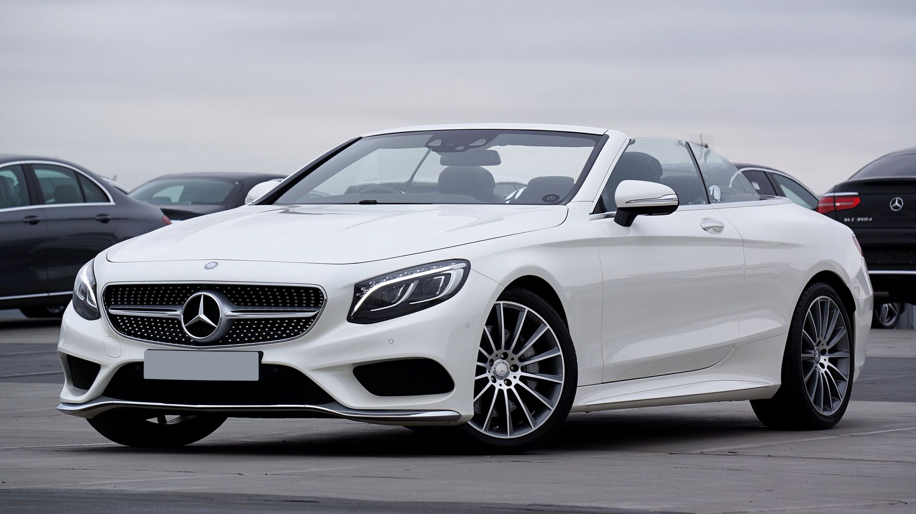 Biały luksusowy kabriolet Mercedes-Benz zaparkowany na zewnątrz Biały luksusowy kabriolet Mercedes-Benz zaparkowany na zewnątrz