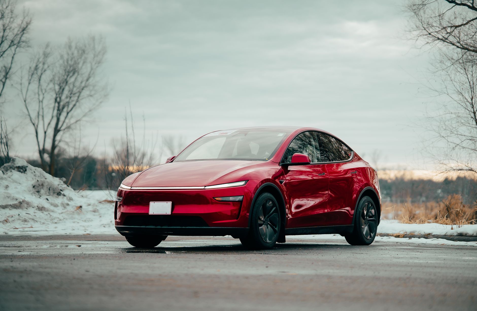 Czerwony elektryczny BYD zaparkowany na śniegu w zimowym krajobrazie